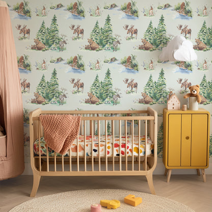 Children's room with crib, yellow cabinet, and forest-themed wallpaper