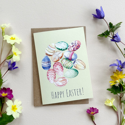 Easter card with colorful eggs and 'Happy Easter!' text, surrounded by spring flowers on a light background